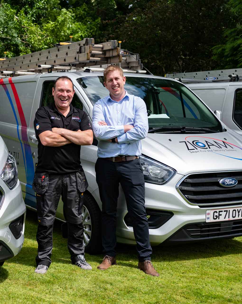 An image of 2 Zicam Project Managers in front of a van