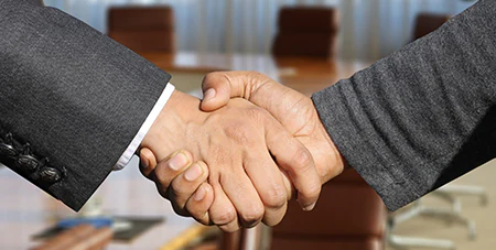 Image of two business people shaking hands to symbolise partnership.